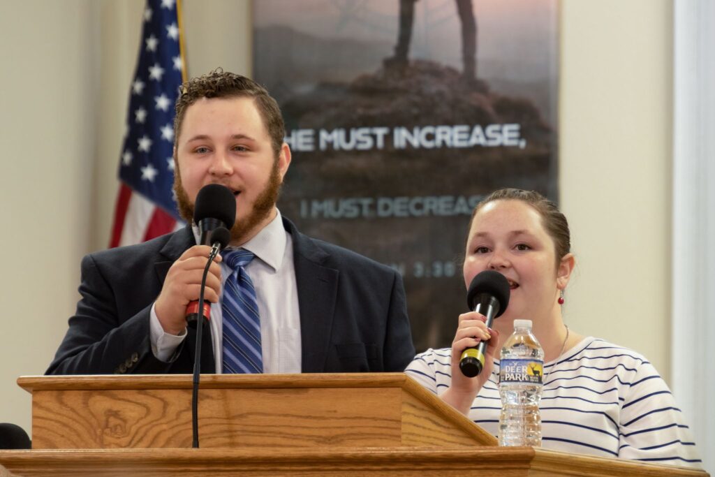 Man and woman singing special at pulpit